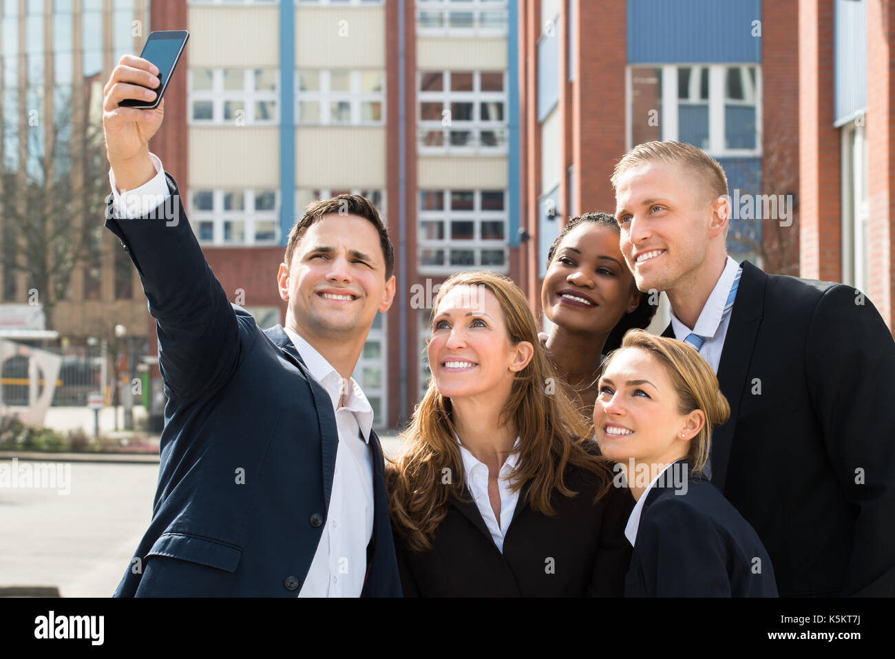 Gruppe von Geschäftsleuten, die selfie mit Handy Stockfoto