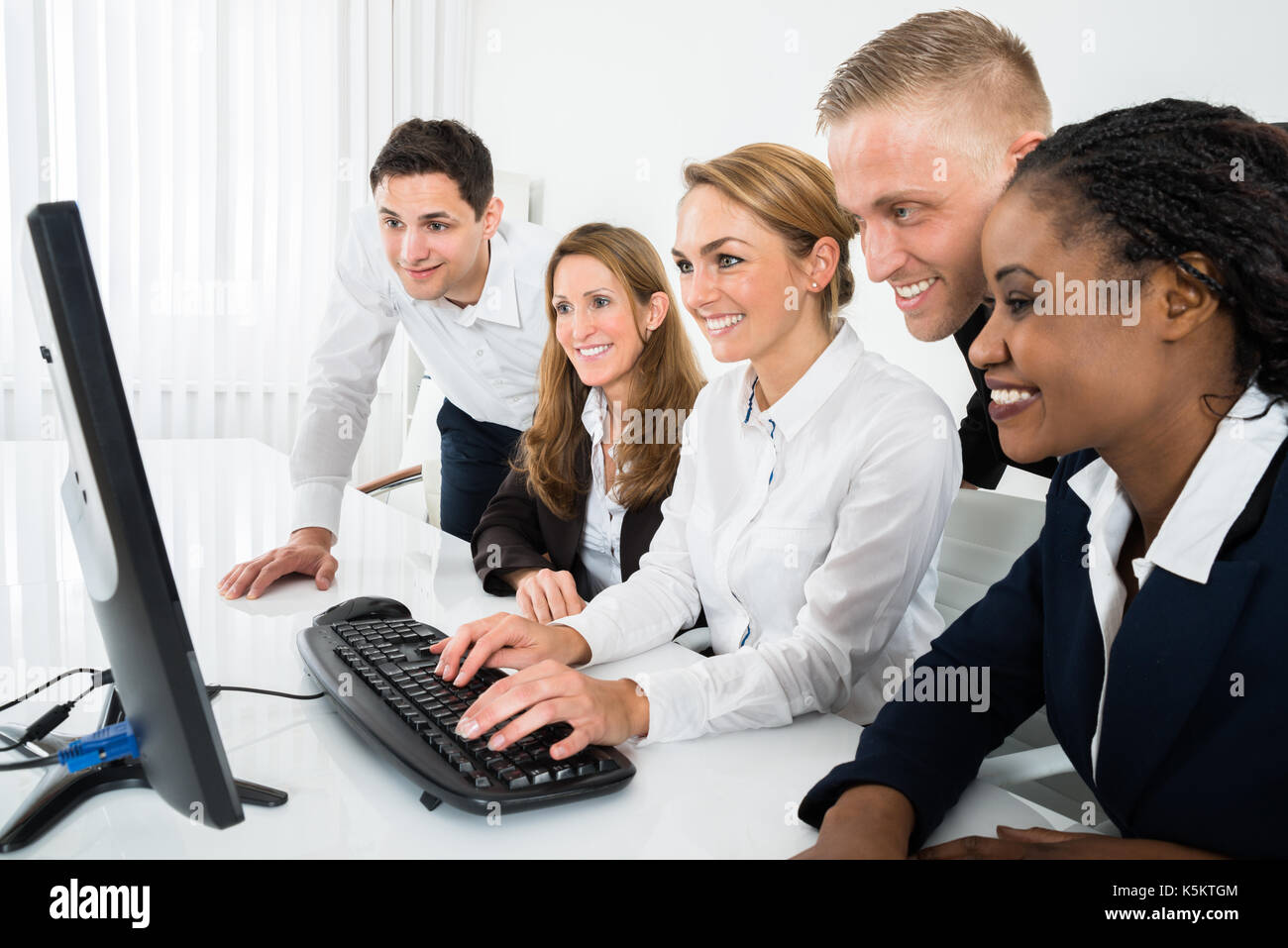 Mannschaft der Geschäftsleute, die sich auf Computer im Büro Stockfoto