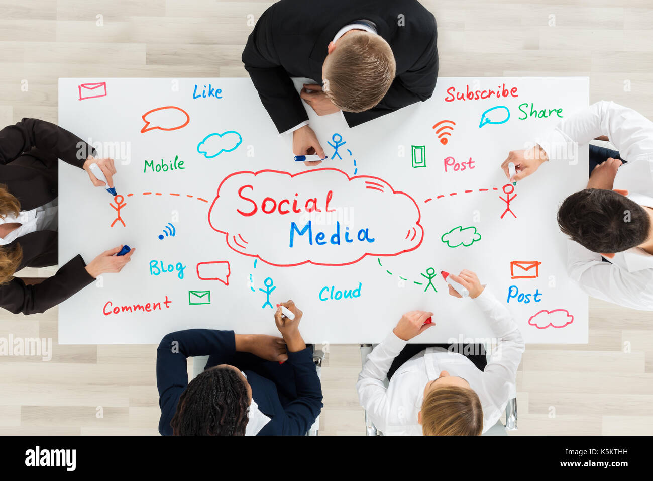 Eine Gruppe von Mitarbeitern, die Sozialen Medien Diagramm am Schreibtisch Stockfoto