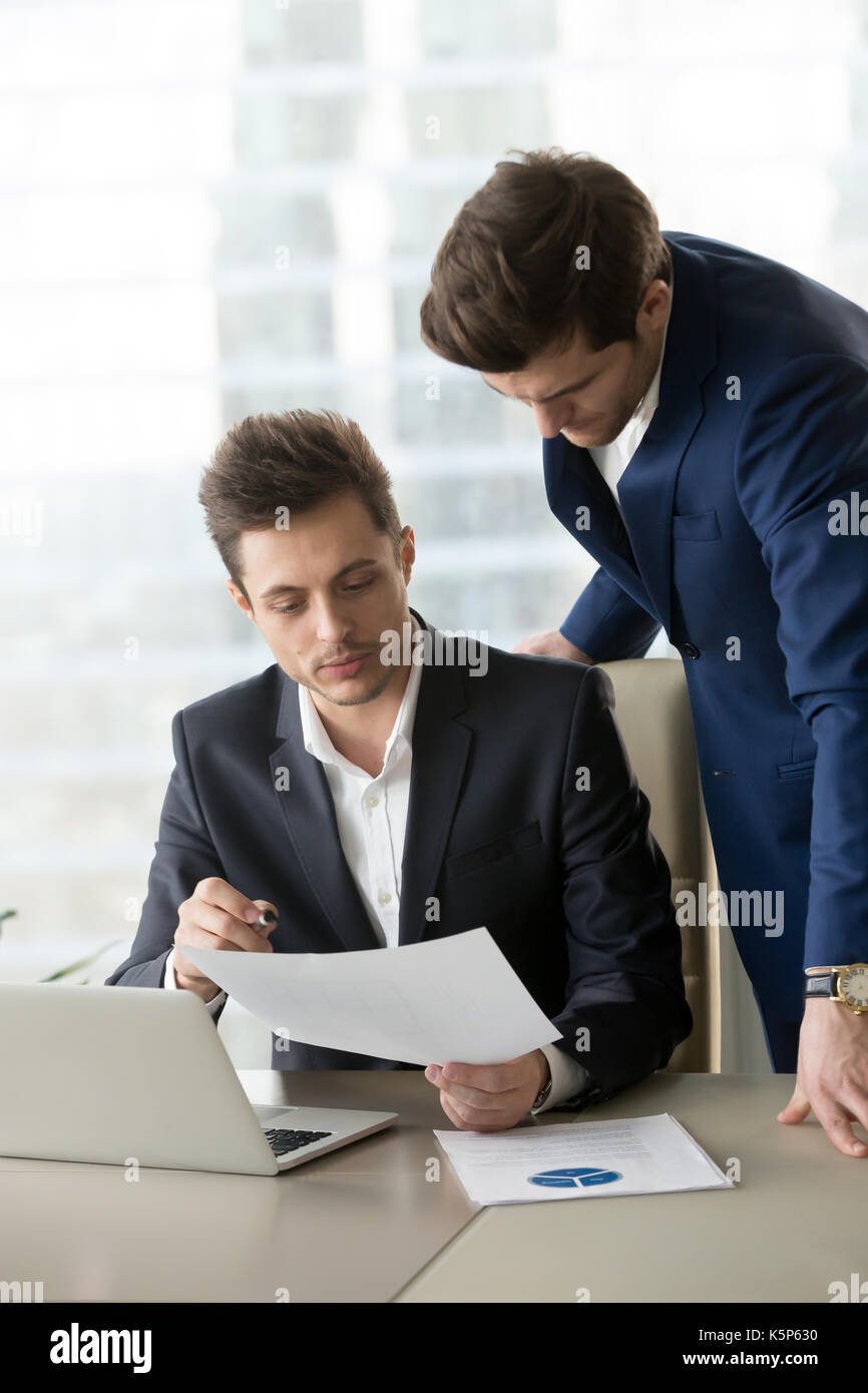 Mitarbeiter erklären Details im Dokument zu Boss Stockfoto