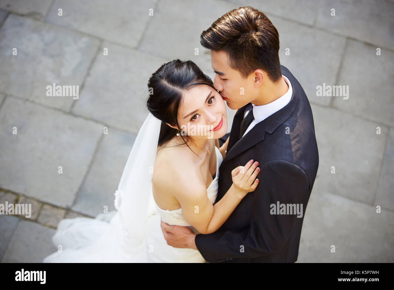 Junge asiatische Braut und Bräutigam umarmen Küssen tanzen in Open Air, hohe Blickwinkel betrachten. Stockfoto