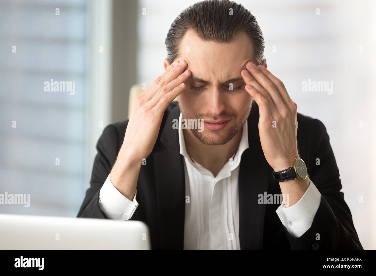Erschöpft Geschäftsmann mit einem Kopfschmerzen nach langen Arbeitszeiten. Stockfoto