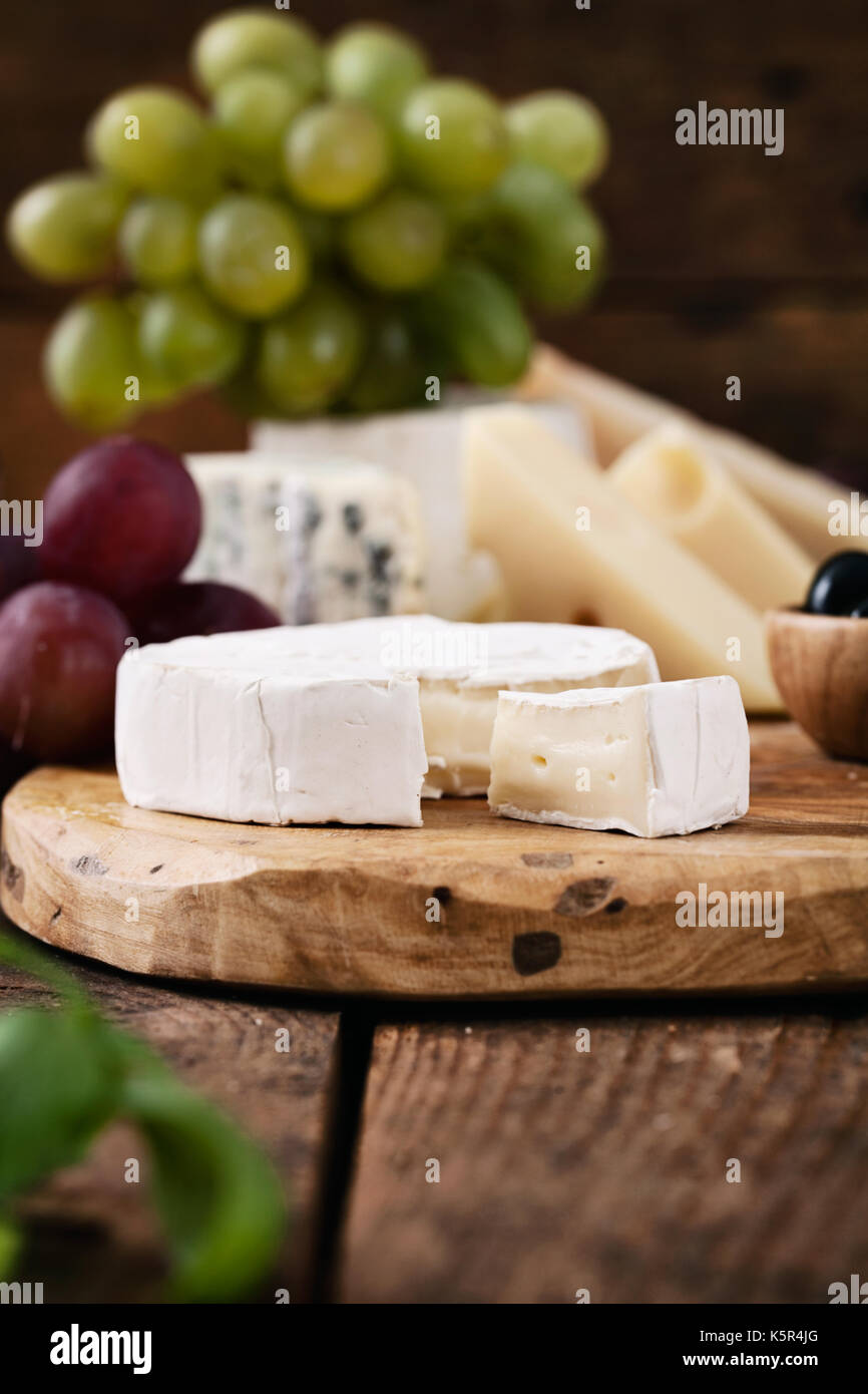 Käse-Vielfalt. Essen-Hintergrund.  Frische Zutaten auf Holz Stockfoto