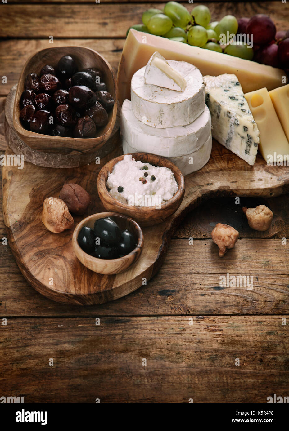 Käse-Vielfalt. Essen-Hintergrund.  Frische Zutaten auf Holz Stockfoto
