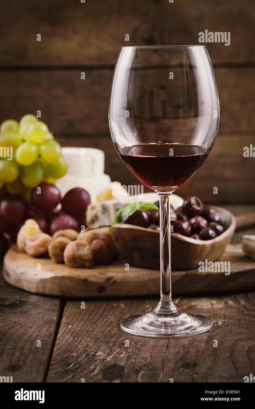 Rotwein mit Käse-Vielfalt. Essen-Hintergrund.  Frische Snacks auf Holz Stockfoto