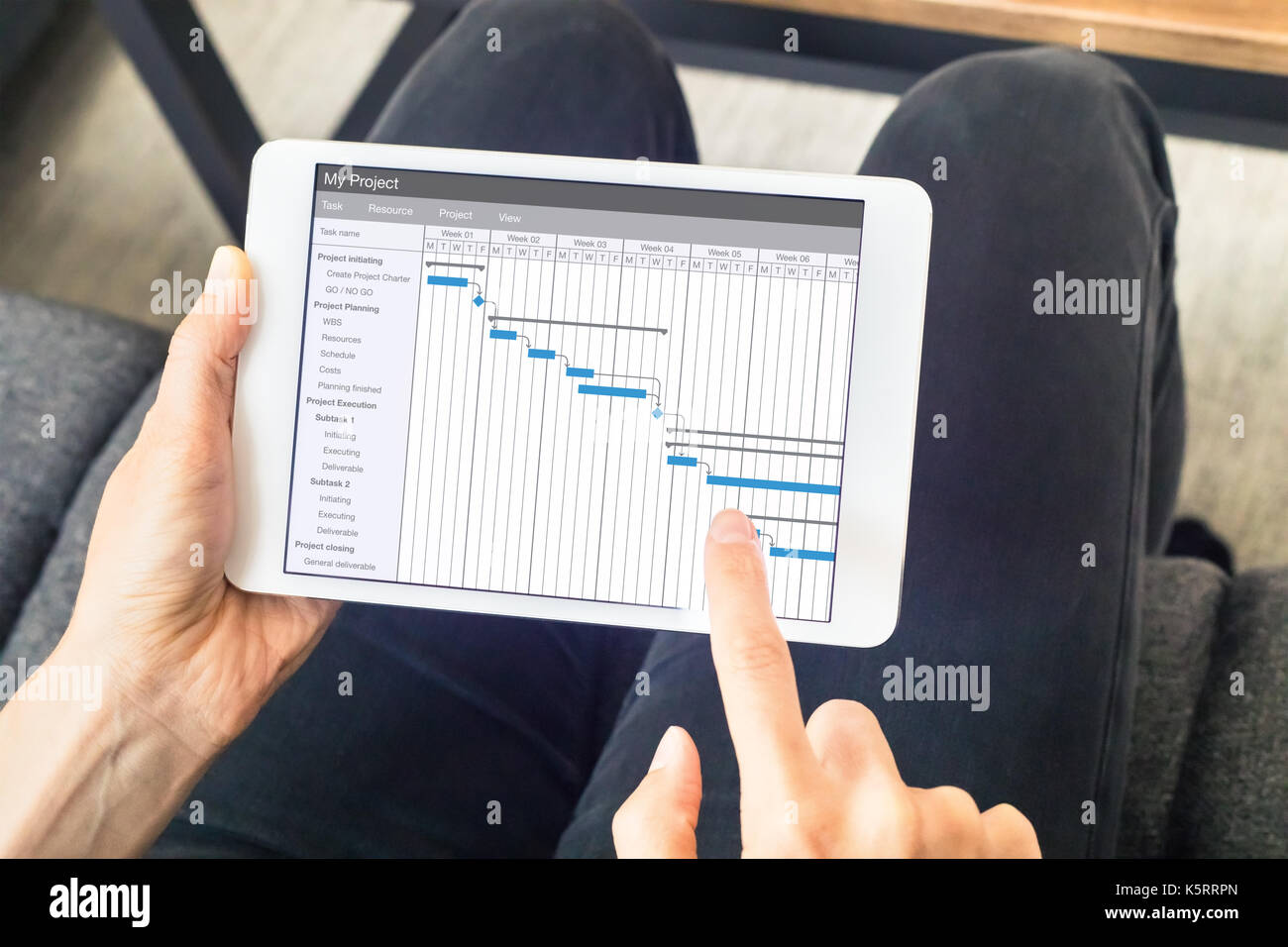 Projekt Manager arbeiten mit Gantt-diagramm mit der Planung Software auf digital Tablet Computer den Zeitplan und Fristen zu aktualisieren. Stockfoto