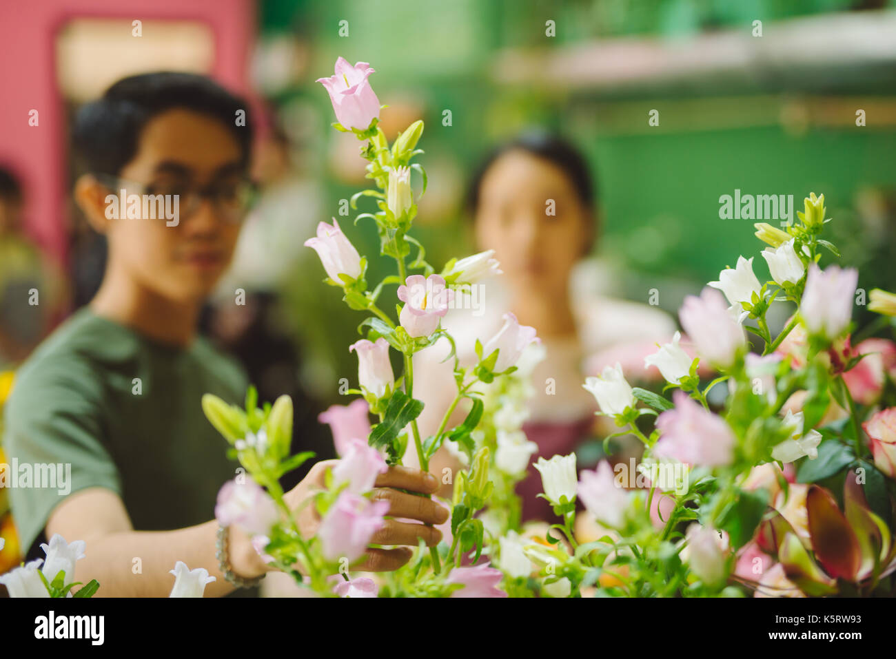 Florist guiding männlichen Kunden in kaufende Blumen bei Store Stockfoto
