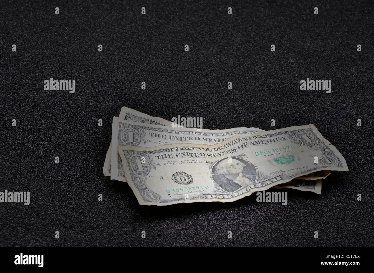 Dollar Bill auf schwarzem Sand schließen Foto Stockfoto