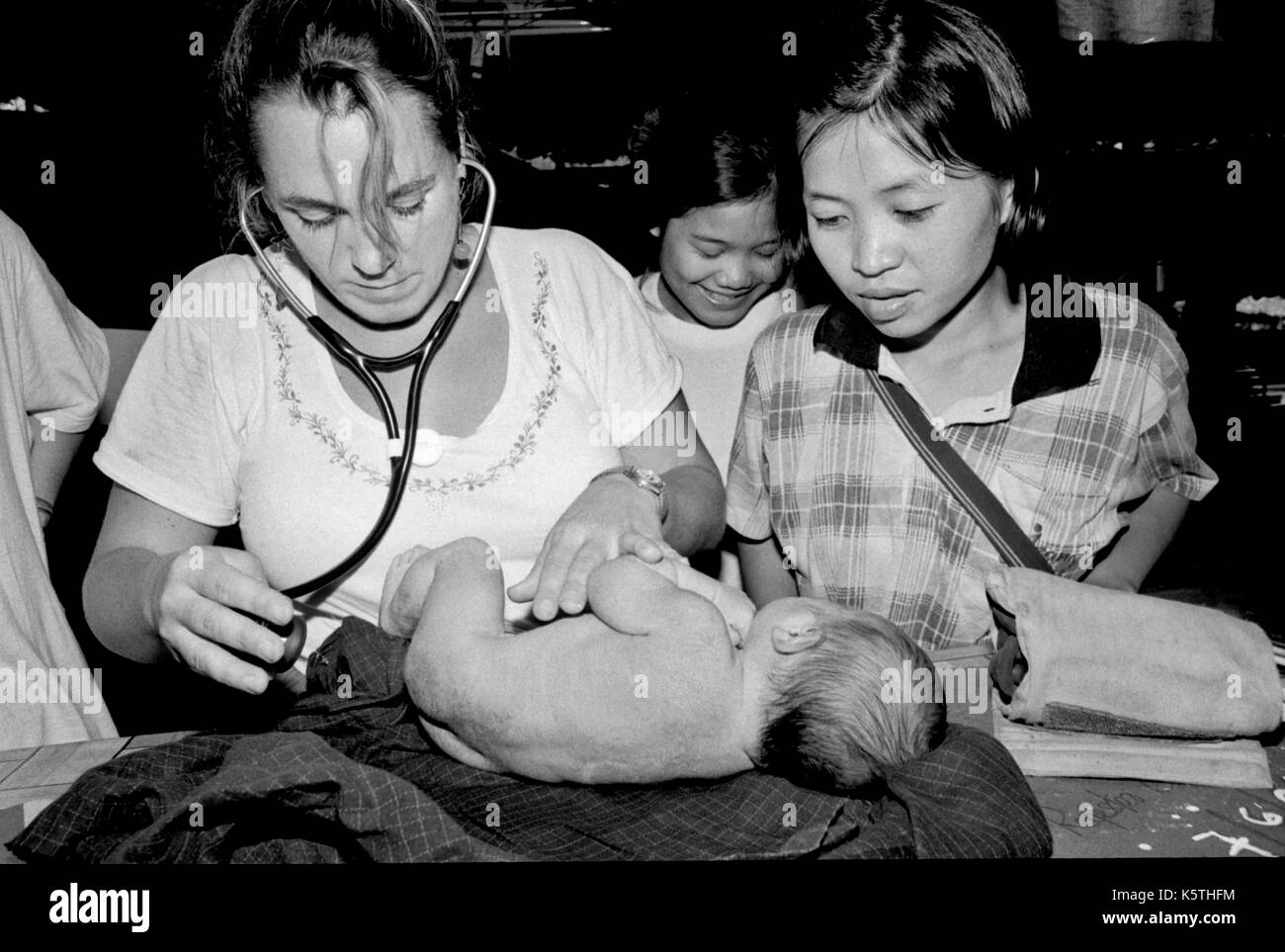 Dr. Mary Washburne untersucht ein Kind links im Wald an ist Geburt (mit Plazenta) an Shok La Flüchtlingslager im Nordwesten von Thailand; ein Lager nur für diejenigen mit Cholera Symptome zu sterben. September, 1996. Stockfoto