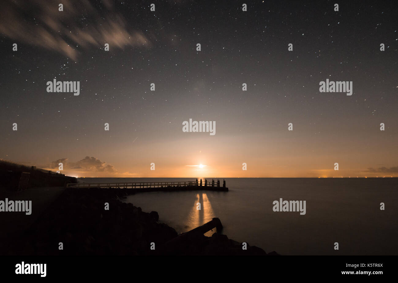 Geschossen wurde, während der Mond am Afsluitdijk auf dem ijselmeer Seite der Straße genommen. Eine schöne Komposition mit Sternen und dem weichen gelben Mond Licht. Stockfoto