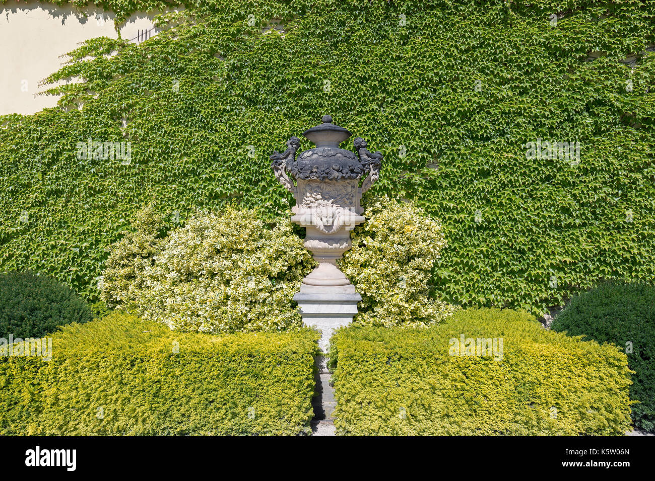 Statue und Klettern Weinpflanze auf eine Wand an der Vrtba Garten (Vrtbovská zahrada) in Prag, Tschechische Republik, gesehen von der Vorderseite an einem sonnigen Tag. Stockfoto