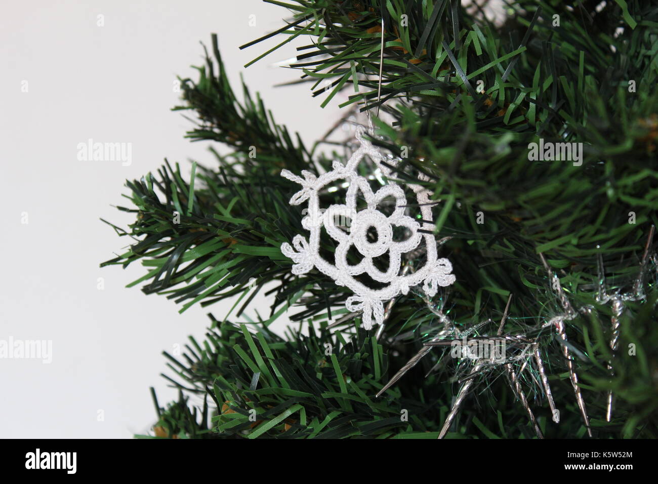 Handgefertigte Schneeflocke Schmuck am Weihnachtsbaum mit weißem Hintergrund. Nahaufnahme, flachen konzentrieren. Stockfoto