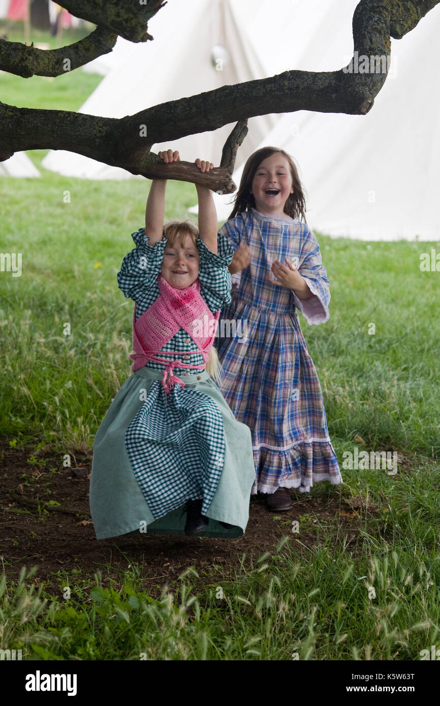 Mädchen Schwingen auf einem Zweig in Tracht an einem Reenactment Stockfoto