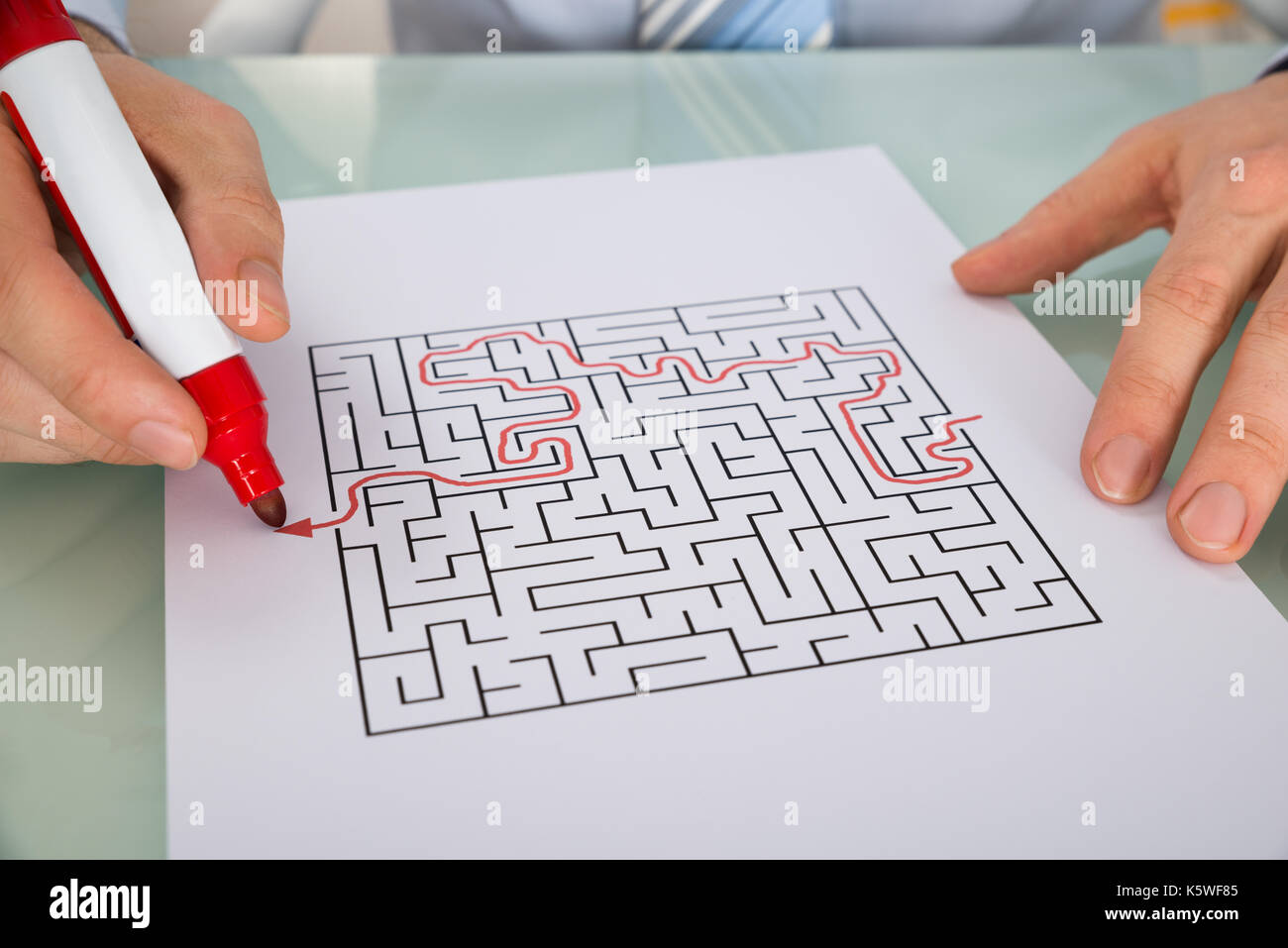 Nahaufnahme der Person Lösung Labyrinth Puzzle mit roten Marker Stockfoto