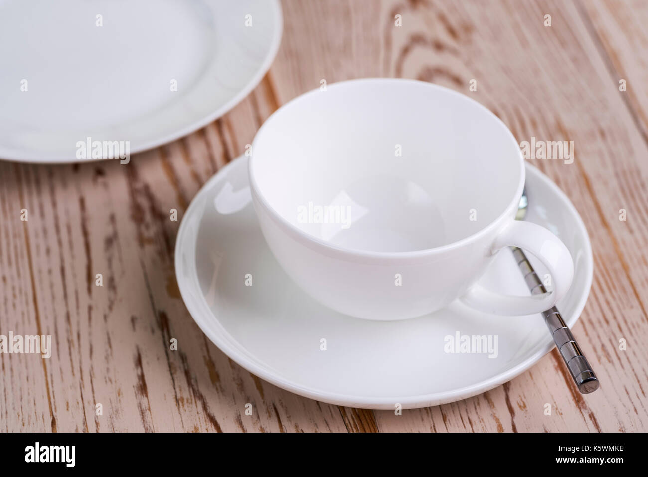 Tasse und Untertasse mit Platte auf distressed Holztisch. Stockfoto