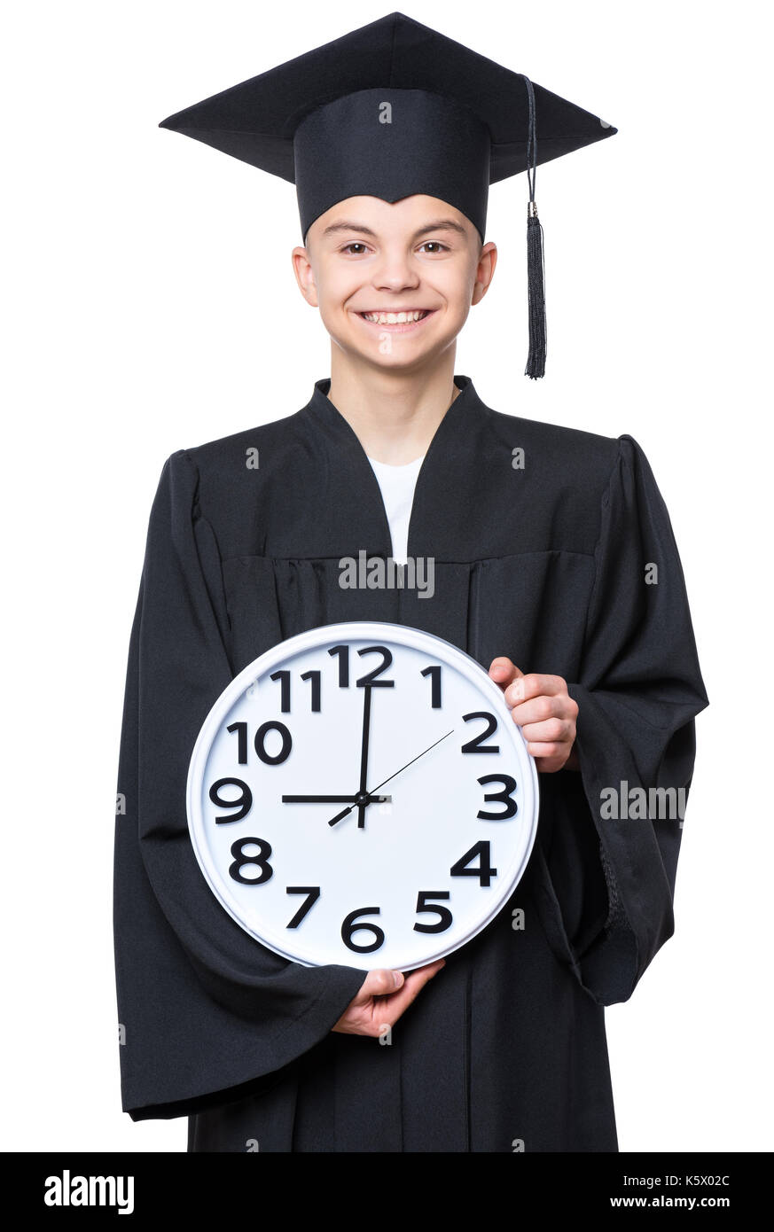 Portrait von Absolvent jugendlich junge Studenten in schwarze Graduierung Kleid mit Hut, die große Uhr - auf weißem Hintergrund. Kind wieder in die Schule, educa Stockfoto