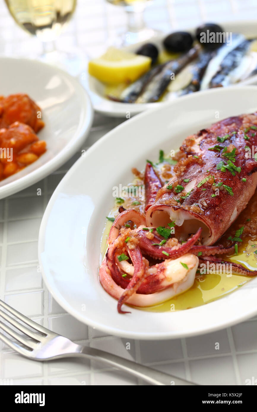 Sautierte Calamari mit Petersilie und Knoblauch, spanische Tapas essen, calamar a la plancha Stockfoto