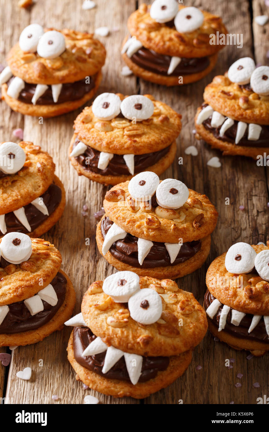Halloween Essen: Monster der nussige Cookies mit Schokoladencreme close-up auf dem Tisch. Vertikale Stockfoto