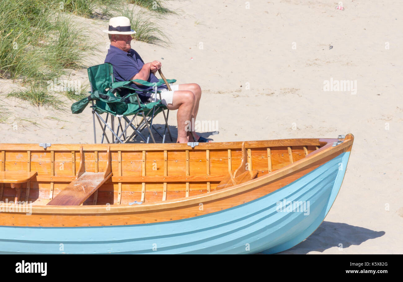 Älterer Mann saß im Stuhl von Boot, Porth Nefyn, North Wales, Vereinigtes Königreich, Großbritannien Stockfoto