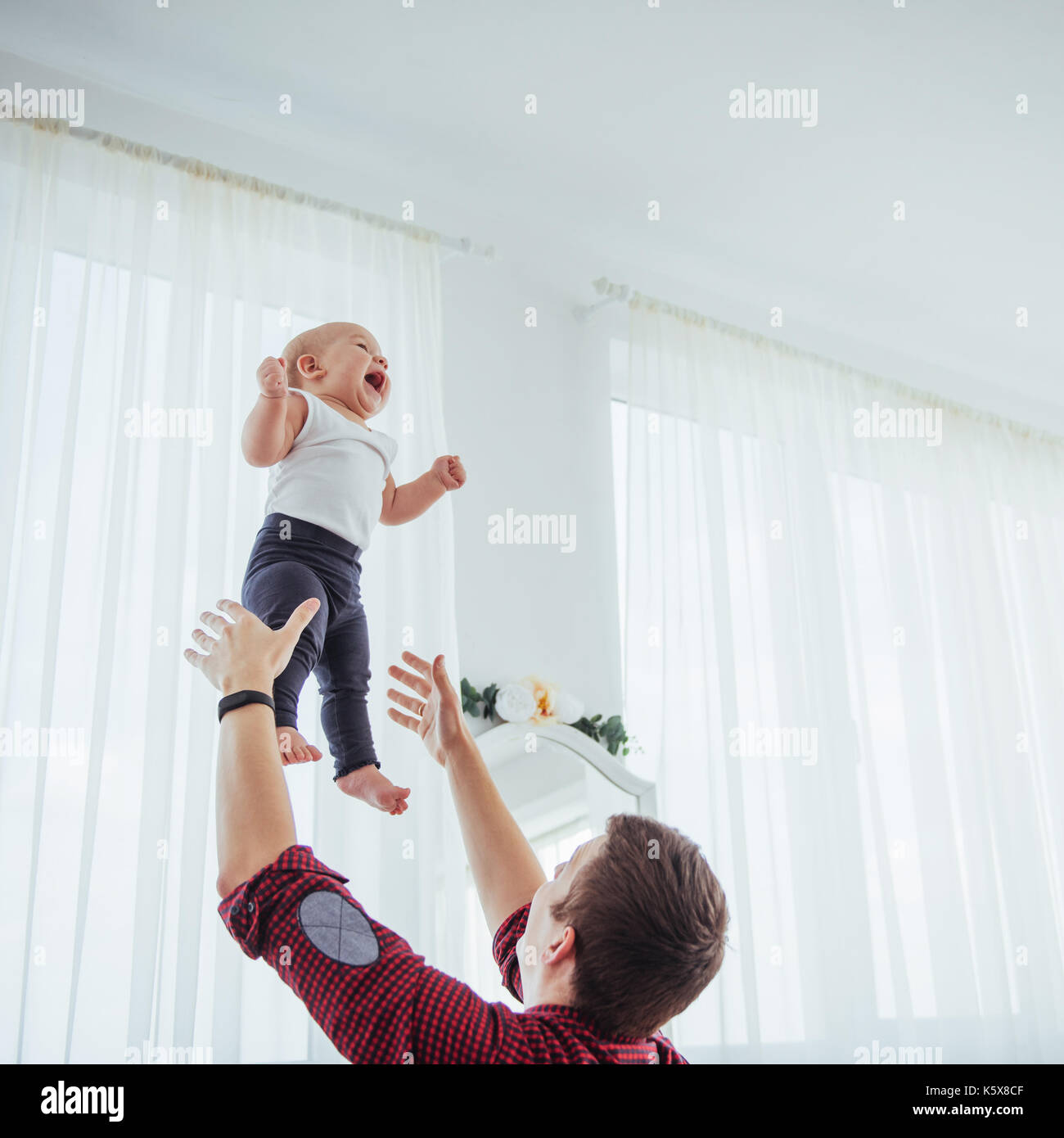 Vater werfende Hand Hohe Luft fröhliche Tochter. Stockfoto