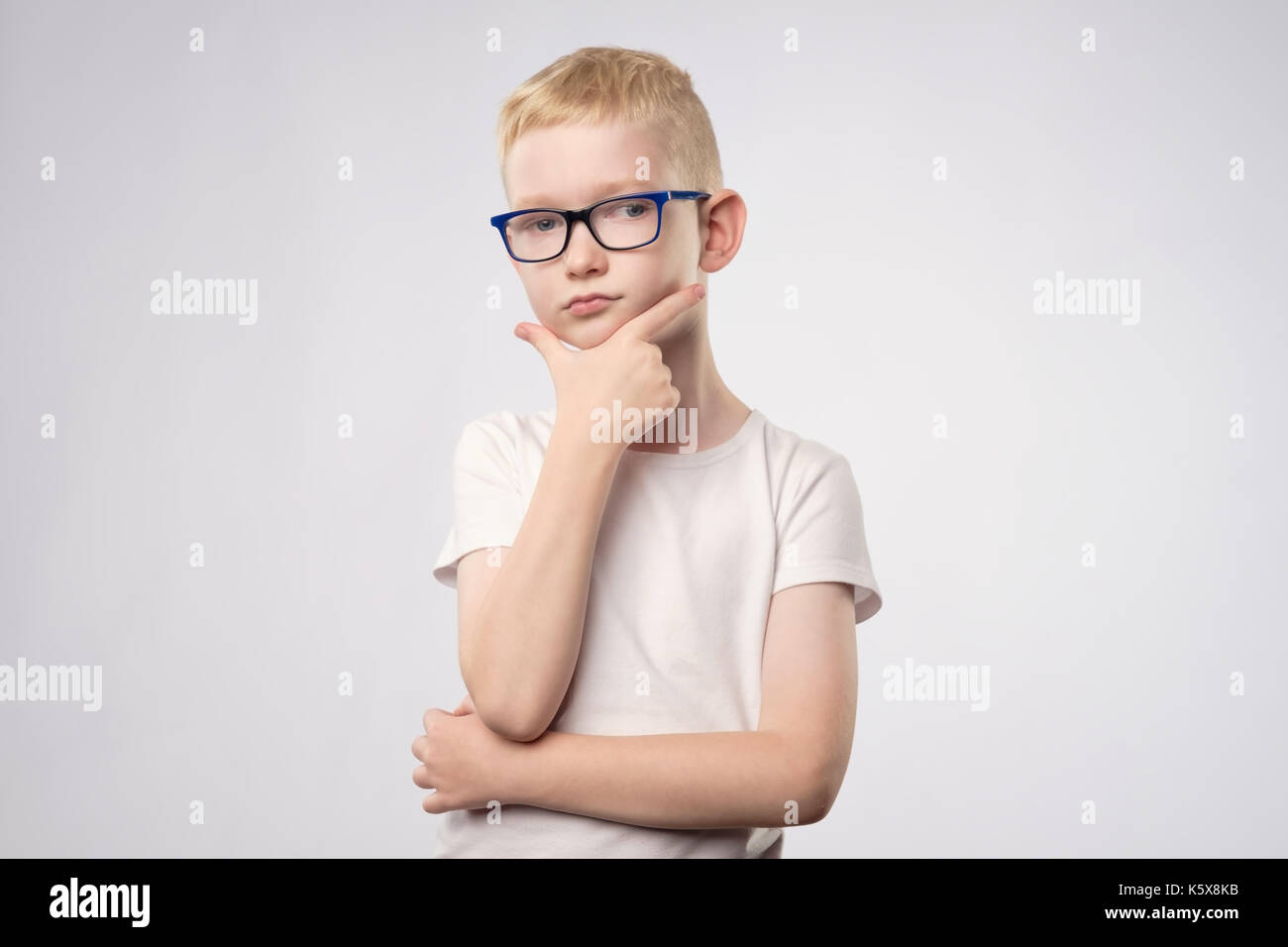 Kaukasische Teenager mit blonden Haaren und Brille isoliert Denken auf weißem Hintergrund Stockfoto