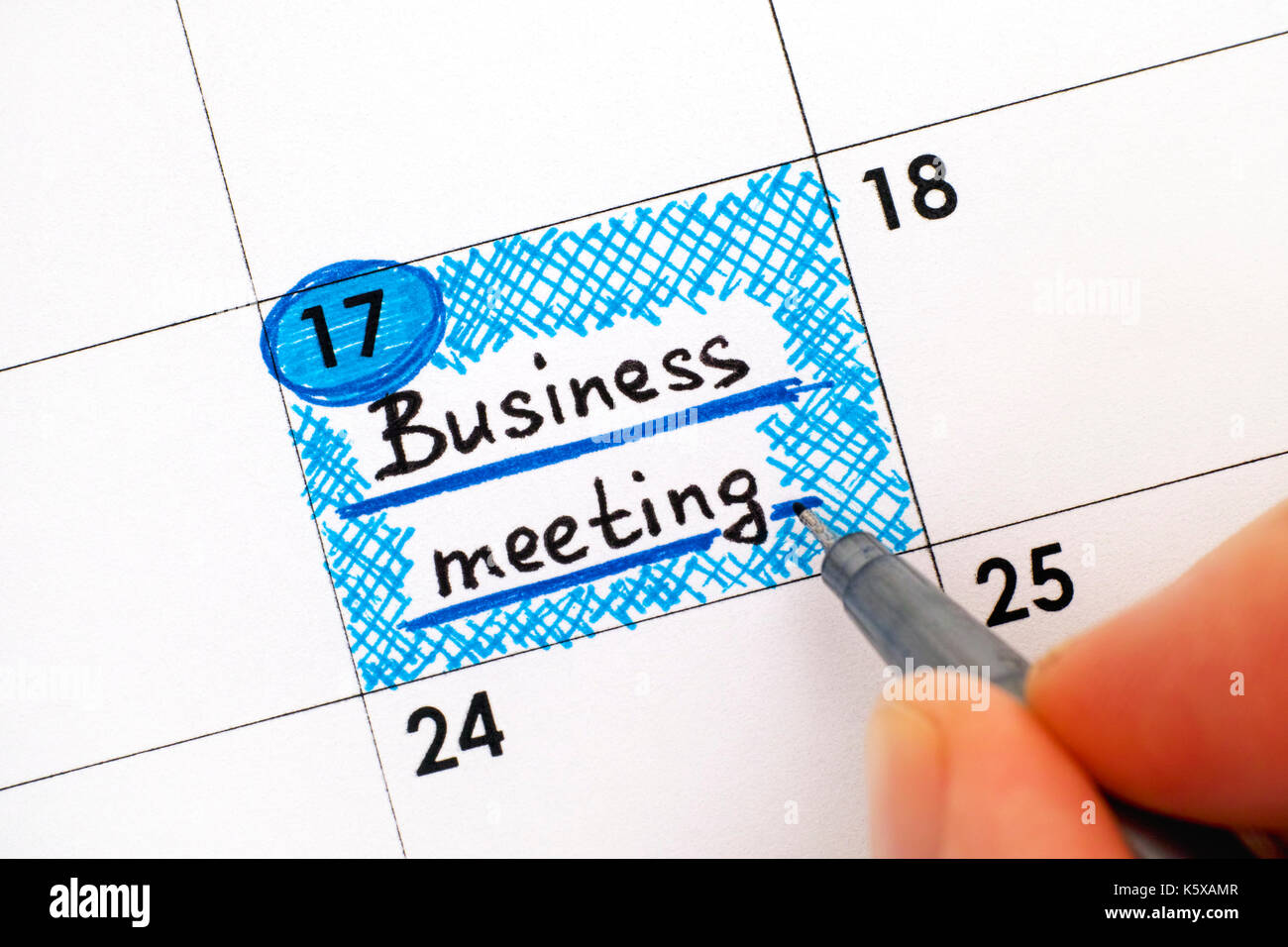 Frau Finger mit Pen schreiben Erinnerung Business Meeting in "Kalender". Close-up. Stockfoto