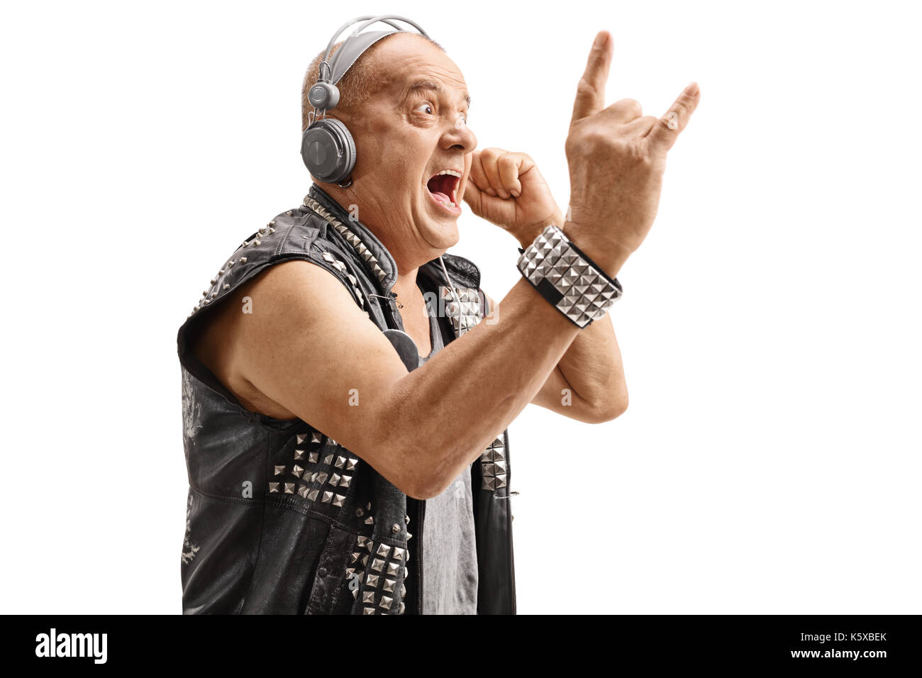Ältere punkers Hören von Musik über Kopfhörer und einen Rock Geste auf weißem Hintergrund Stockfoto