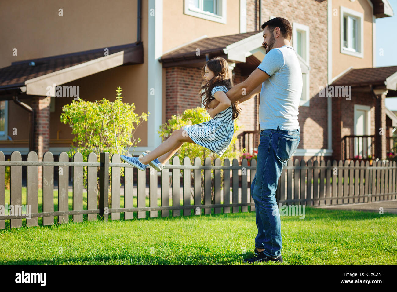 Glückliche junge Vater spinnen seine kleine Tochter Stockfoto