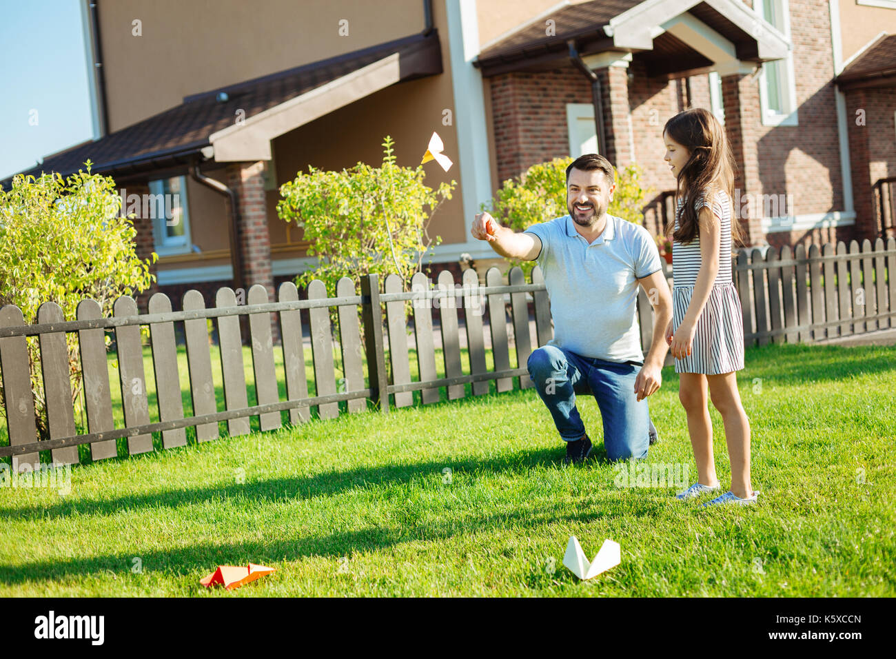 Gerne Vater startet ein Paper Plane im Hinterhof Stockfoto