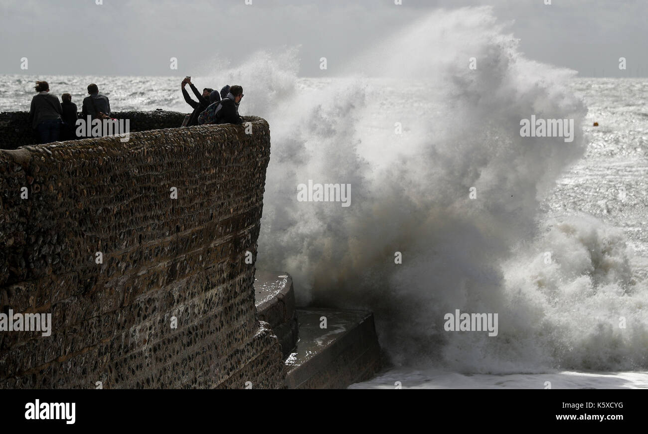 Die Menschen nehmen eine selfie wie Wellen auf Brighton Beach, wie Überschwemmungen Autobahnen, Straßen und Eisenbahnen im Norden von England mit Warnungen von mehr schlechtes Wetter auf dem Weg getroffen hat. Stockfoto