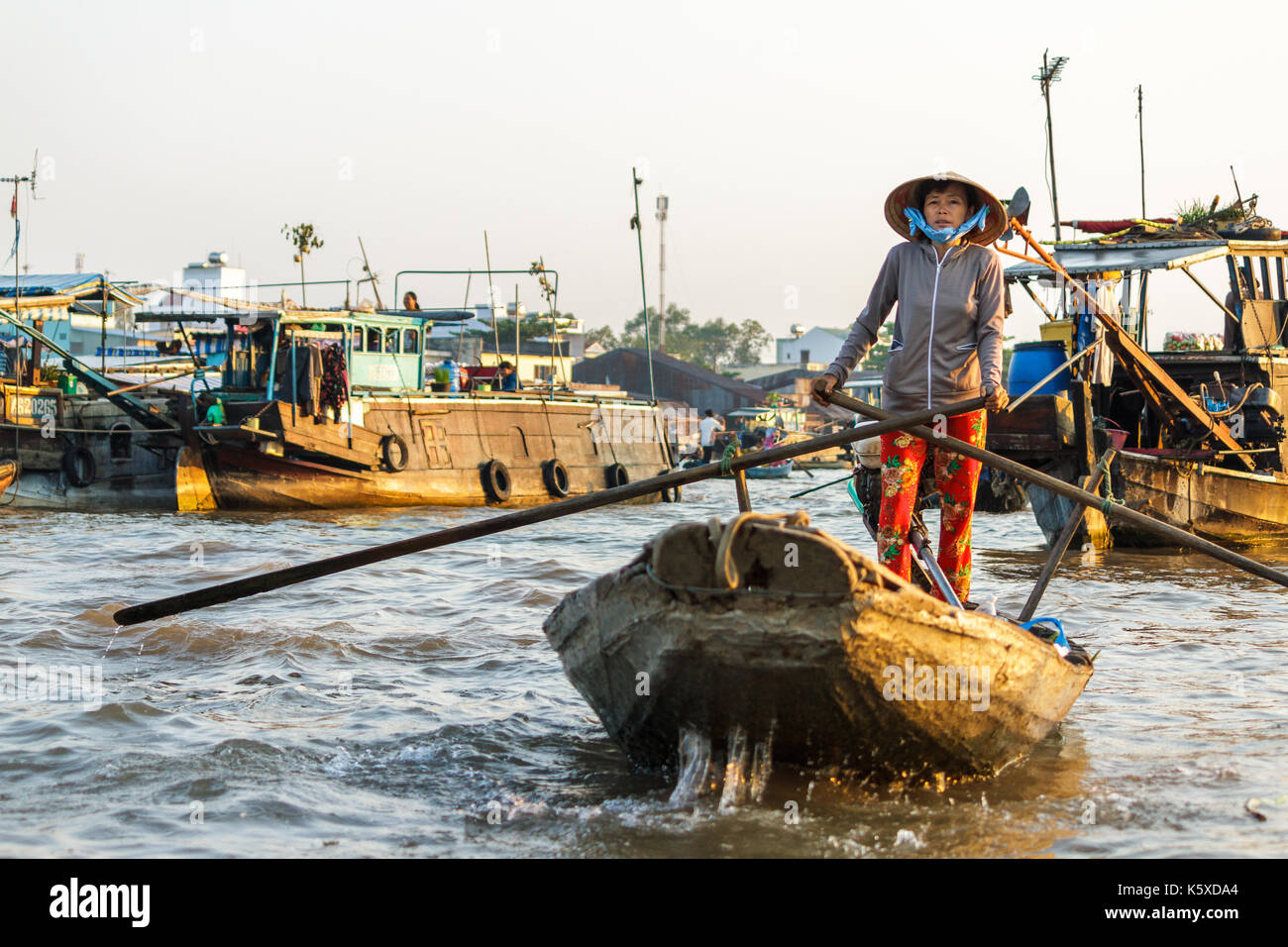 CAN THO, VIETNAM - 3/24/2016: ein Kaufmann paddles Cai Rang Floating Market auf dem Mekong Fluss Produkte an Touristen zu verkaufen. Stockfoto