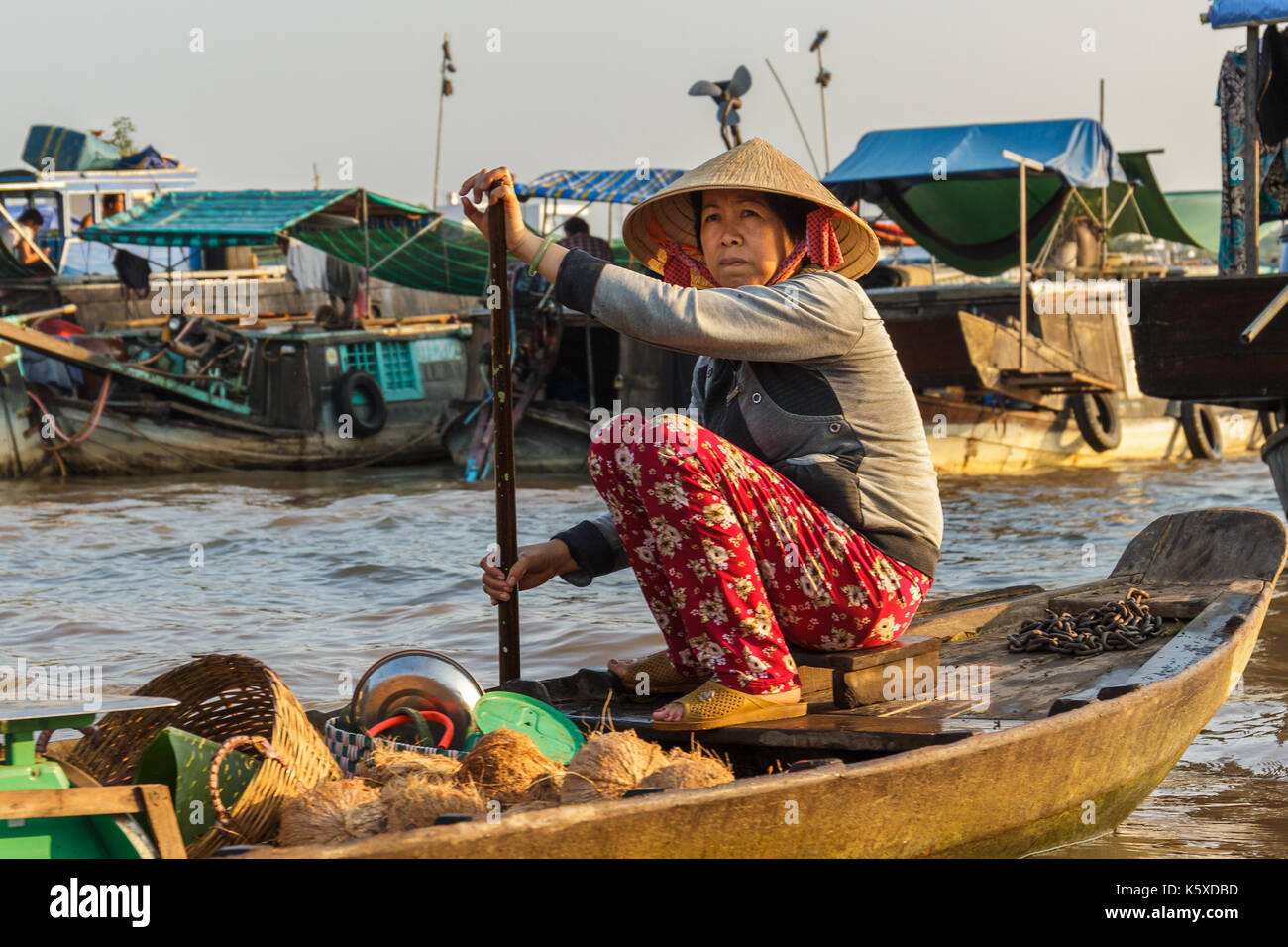 CAN THO, VIETNAM - 3/24/2016: eine Kokosnuss Kaufmann paddles Cai Rang Floating Market auf dem Mekong Fluss Produkte an Kunden zu verkaufen. Stockfoto