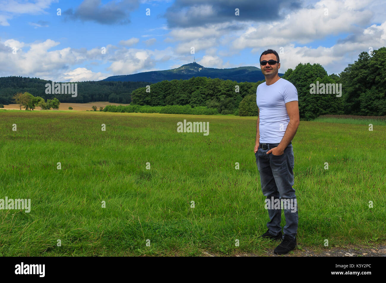 Ein Mann in der Wildnis stehend auf einem Feld in den Hintergrund eines Berges Stockfoto