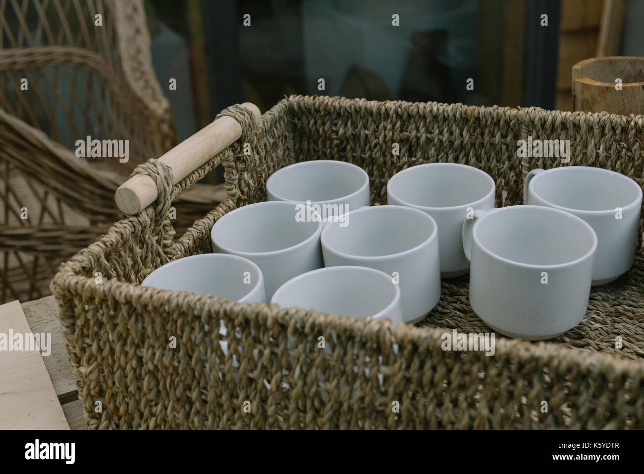 Weiße Tassen in den Korb. Stockfoto
