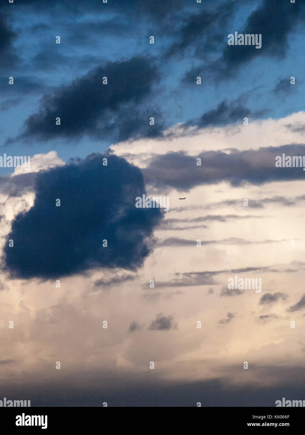 Silhouette eines Flugzeugs fliegen in Richtung auf eine schwarze Wolke Stockfoto