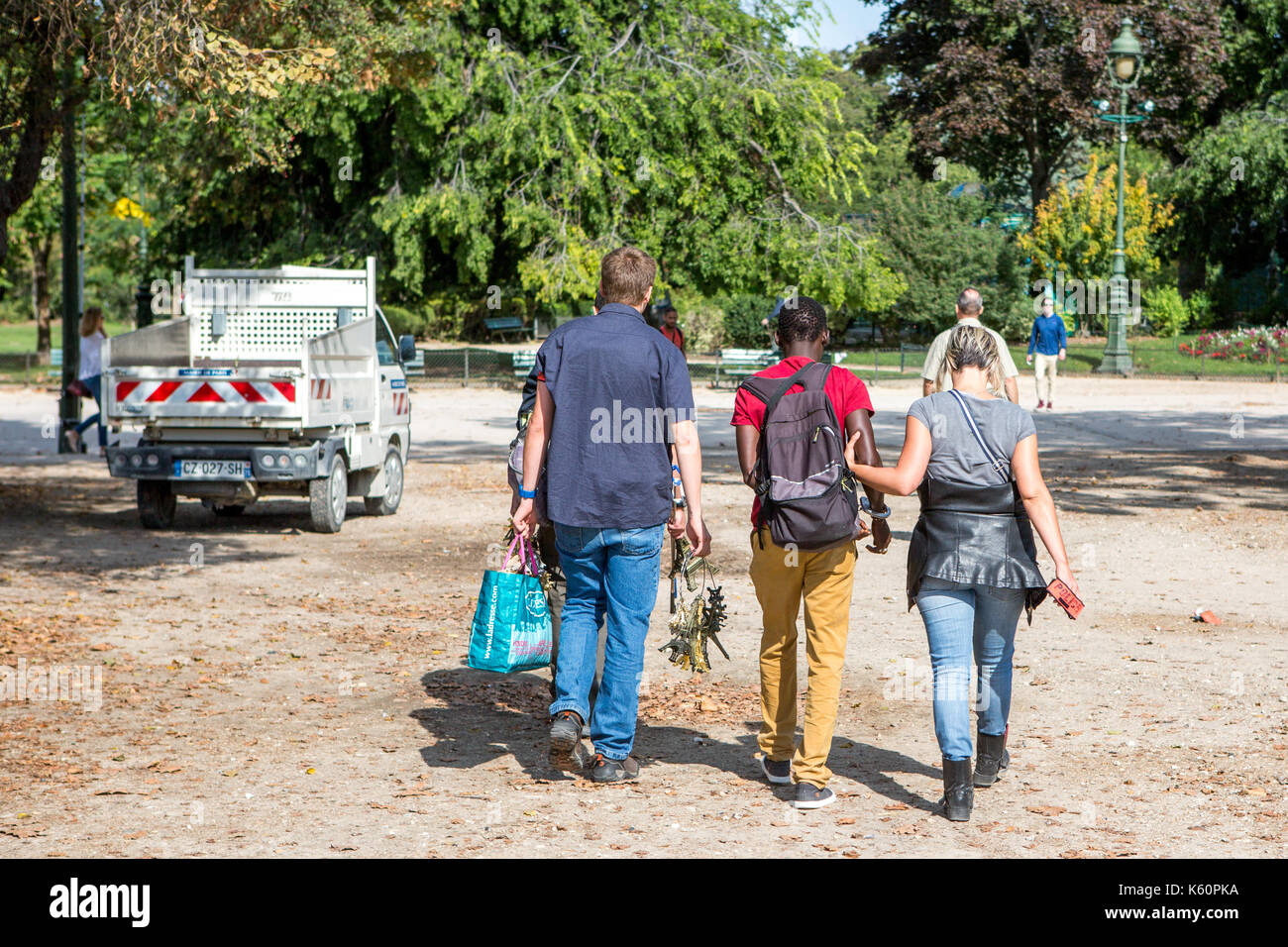 Eine Straße Verkäufer mit Handschellen gefesselt, während sie von der Polizei in der Nähe des Eiffelturm in Paris begleitet wird, Stockfoto