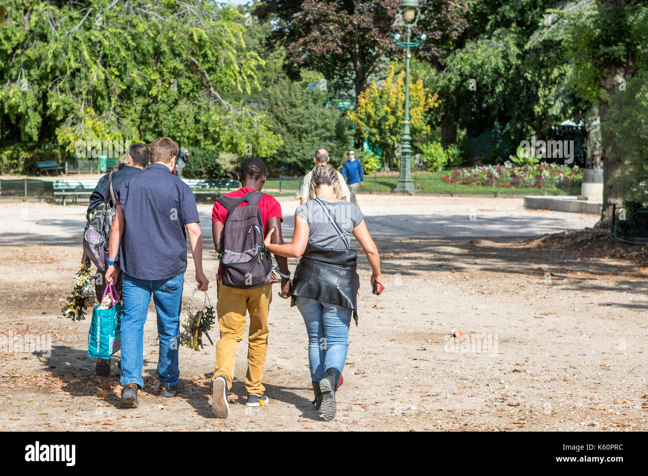 Eine Straße Verkäufer mit Handschellen gefesselt, während sie von der Polizei in der Nähe des Eiffelturm in Paris begleitet wird, Stockfoto
