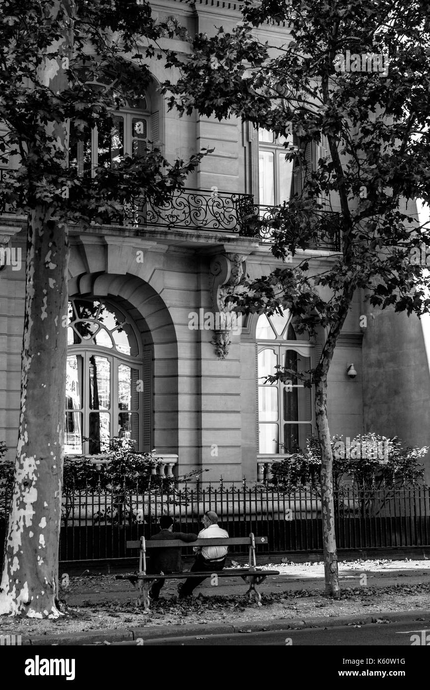 Zwei Männer sitzen auf einer Bank auf einer Pariser Straße Stockfoto