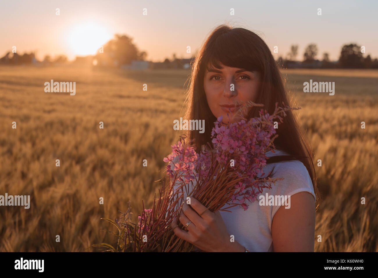 Schöne Mädchen in einem Feld mit Blumen. Stockfoto