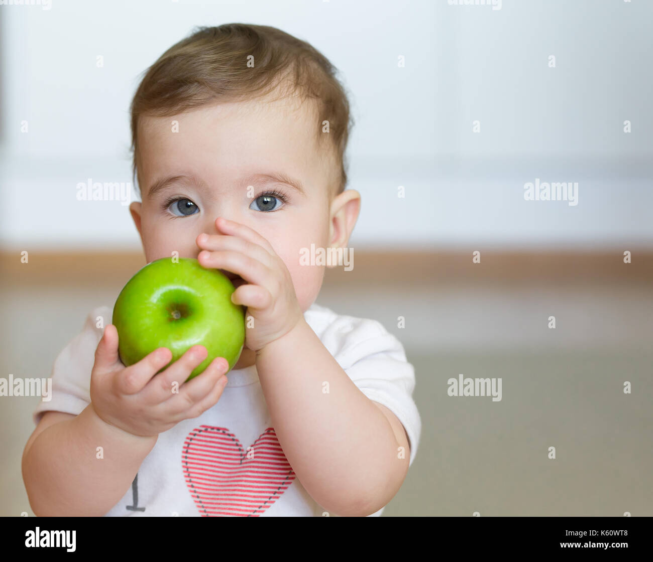 Kleines Kind mit einem Green Apple in seinen Händen. Close up Portrait. Stockfoto