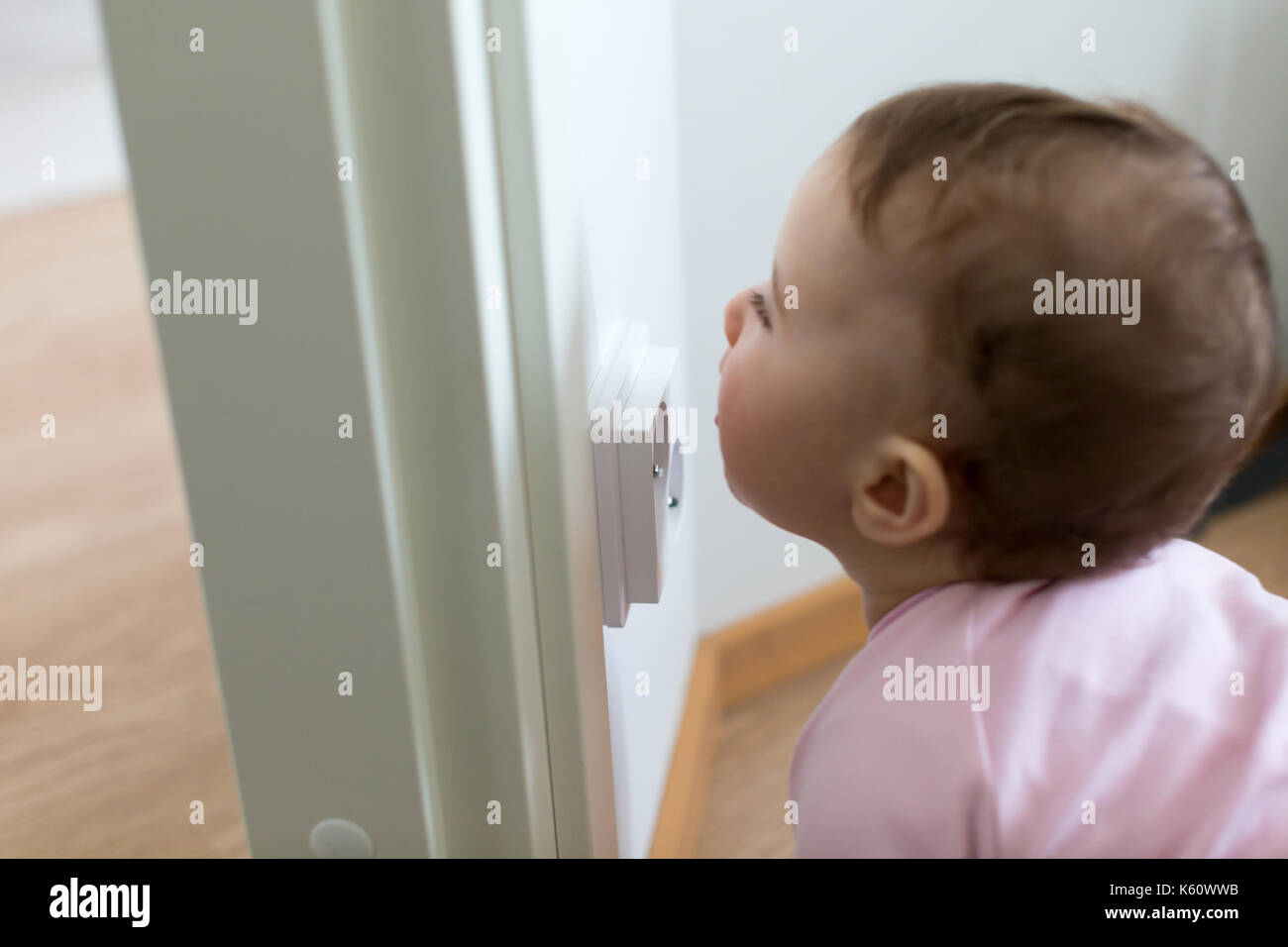 Kleines Kind ist auf der Suche nach einer Steckdose zu Hause. Die Sicherheit der Kinder. Stockfoto