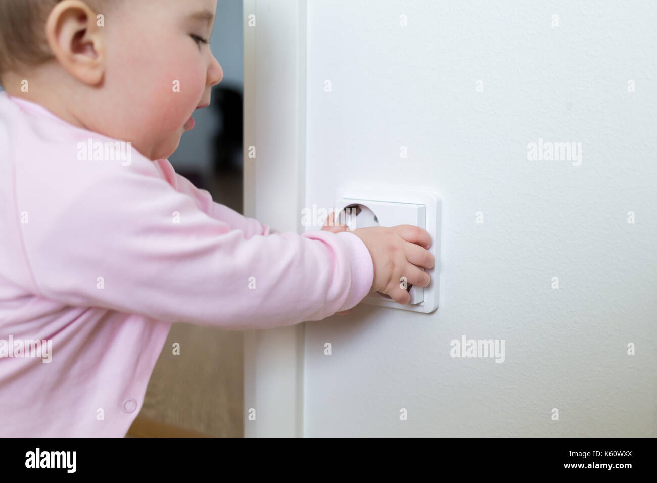 Kleines Kind berührt, eine Steckdose zu Hause. Die Sicherheit der Kinder. Stockfoto