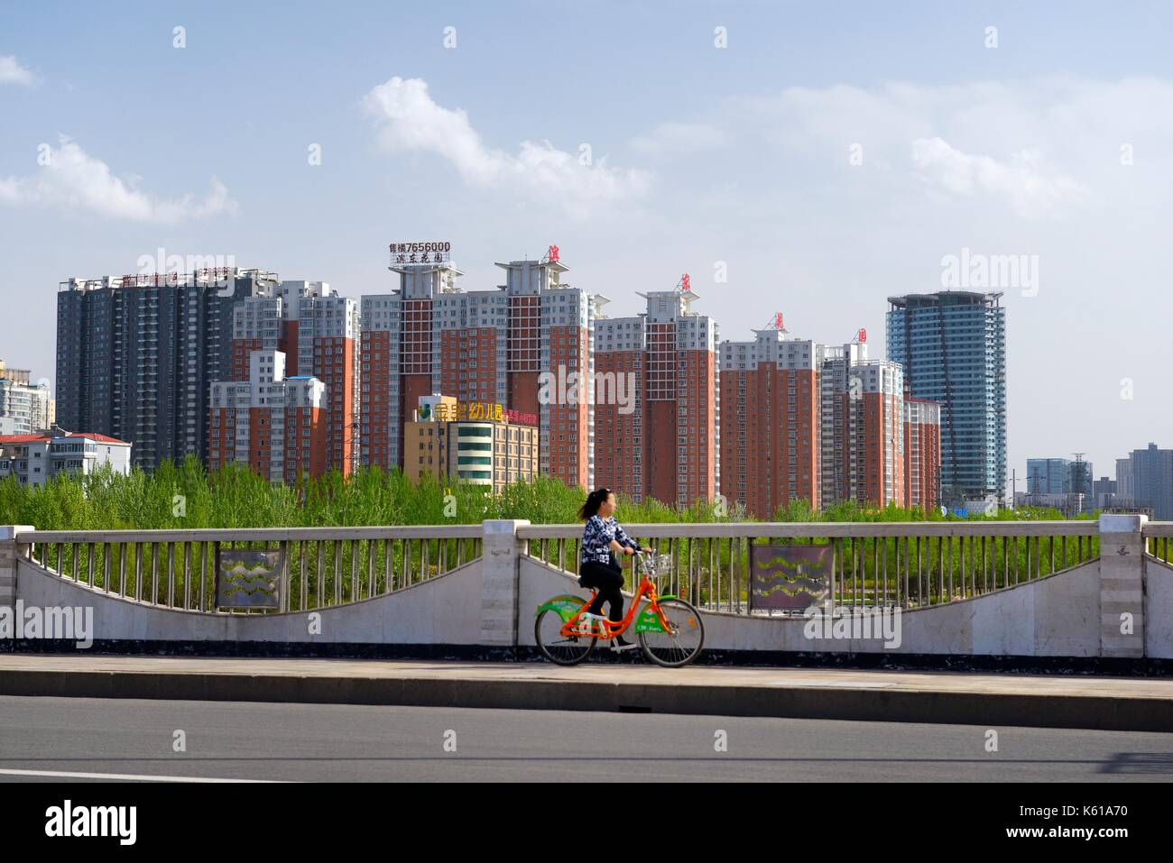 Post-industriellen Ändern der Stadt Taiyuan, Provinz Shanxi. Radfahrer fährt Fahrrad teilen in klare saubere Luft Vergangenheit neue Wohnung Blöcke Stockfoto