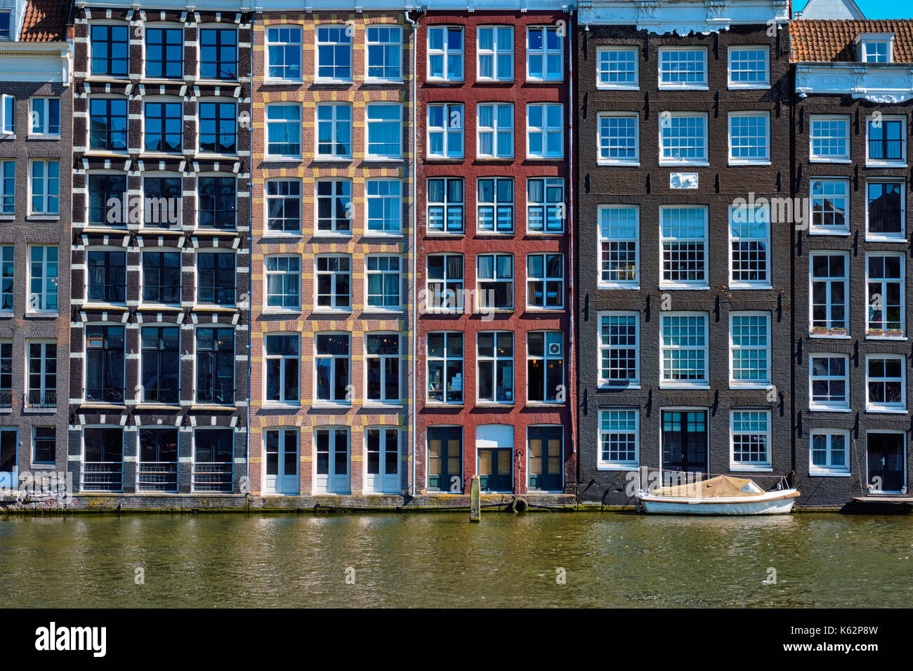 Häuser und Boot auf Gracht in Amsterdam Damrak mit Reflexion. Ams Stockfoto