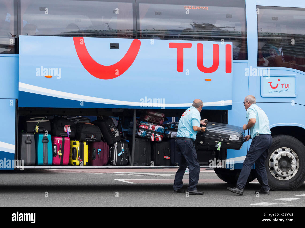 TUI Busfahrer laden Gepäck am Flughafen in Spanien Stockfoto