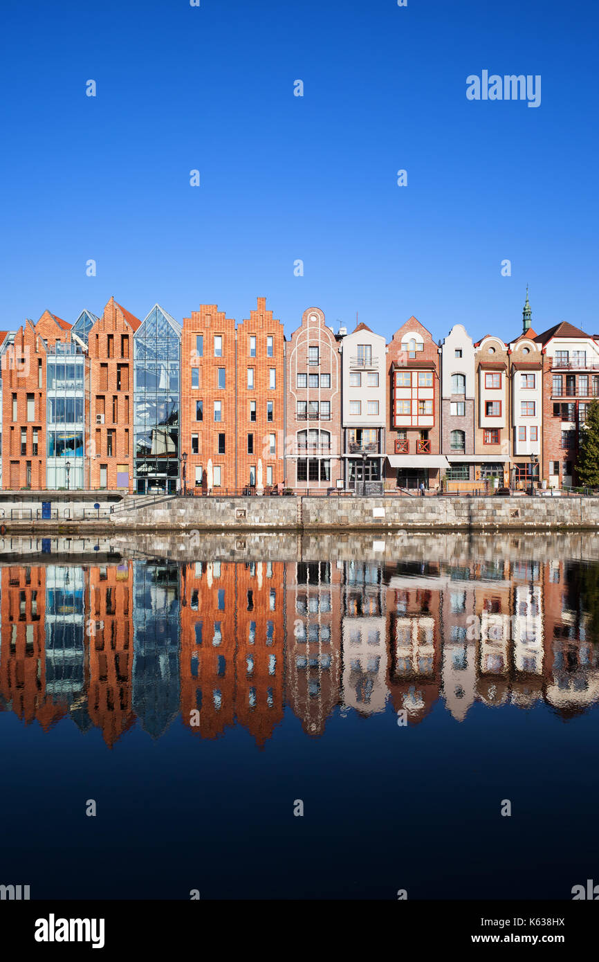 Stadt Danzig in Polen, Reihe von schmalen Häuser am alten Fluss Mottlau mit Spiegel Spiegelbild im Wasser. Stockfoto