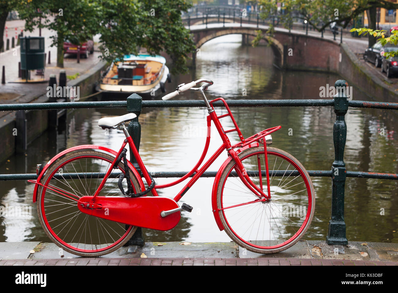 Rote Rad auf einer Brücke über einen Kanal in Amsterdam Stockfoto