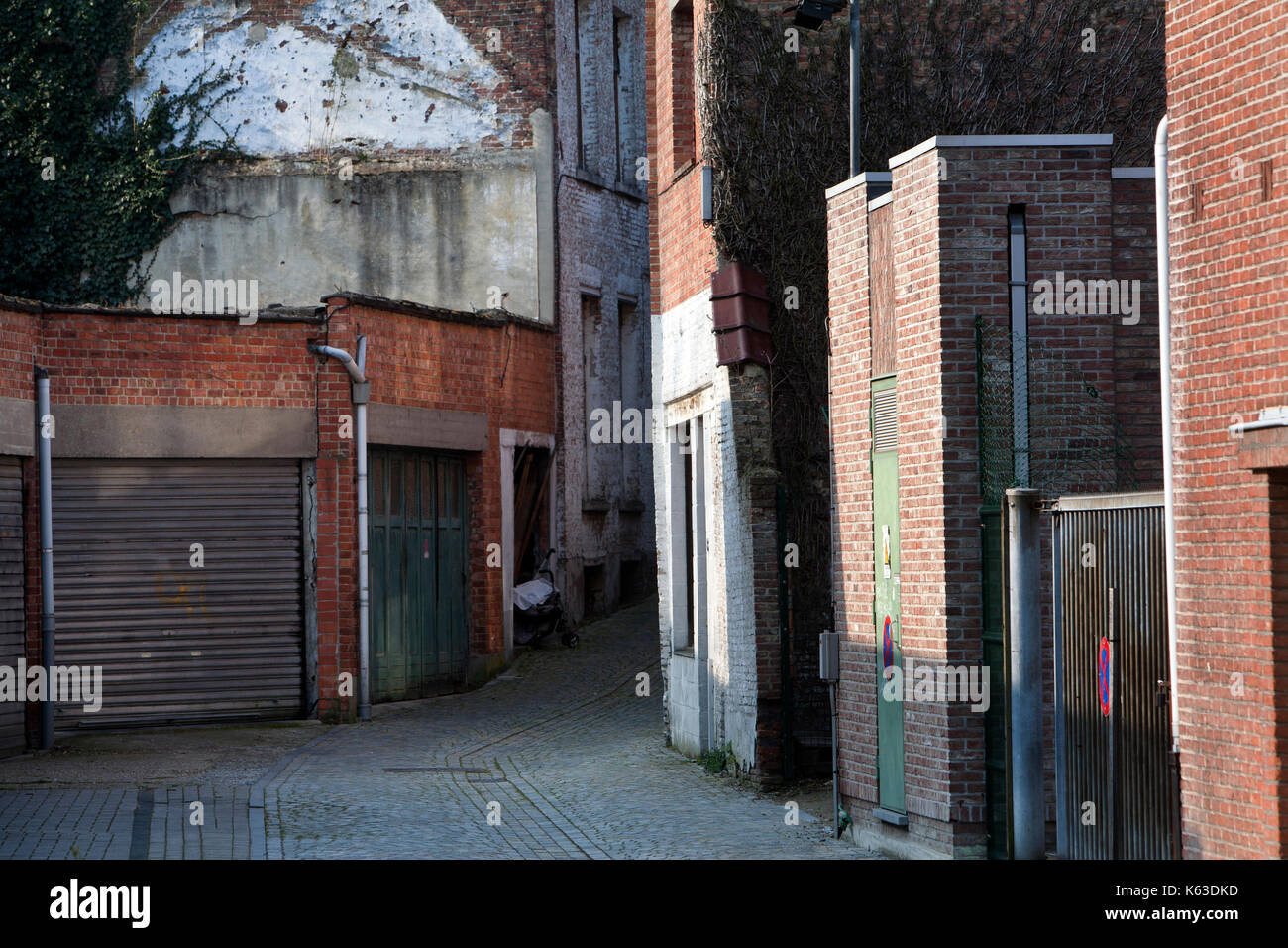 Garagentore und eine kleine dunkle Gasse in einem Wohnviertel von Mechelen in Belgien. Es ist eine alte, aber sauber Nachbarschaft mit einem keine Parkplätze. Stockfoto