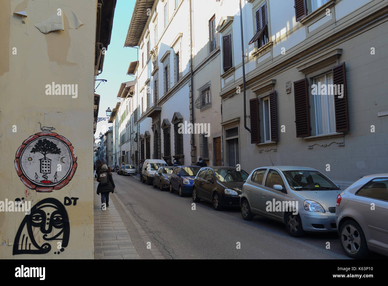 Street Art durch eine Straße mit parkenden Autos. Florenz, Italien. Stockfoto