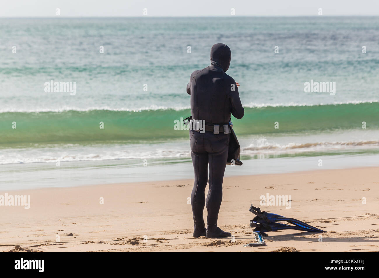 Taucher im Neoprenanzug nicht identifizierten gehen speerfischen von Beach Ocean Eintrag. Stockfoto